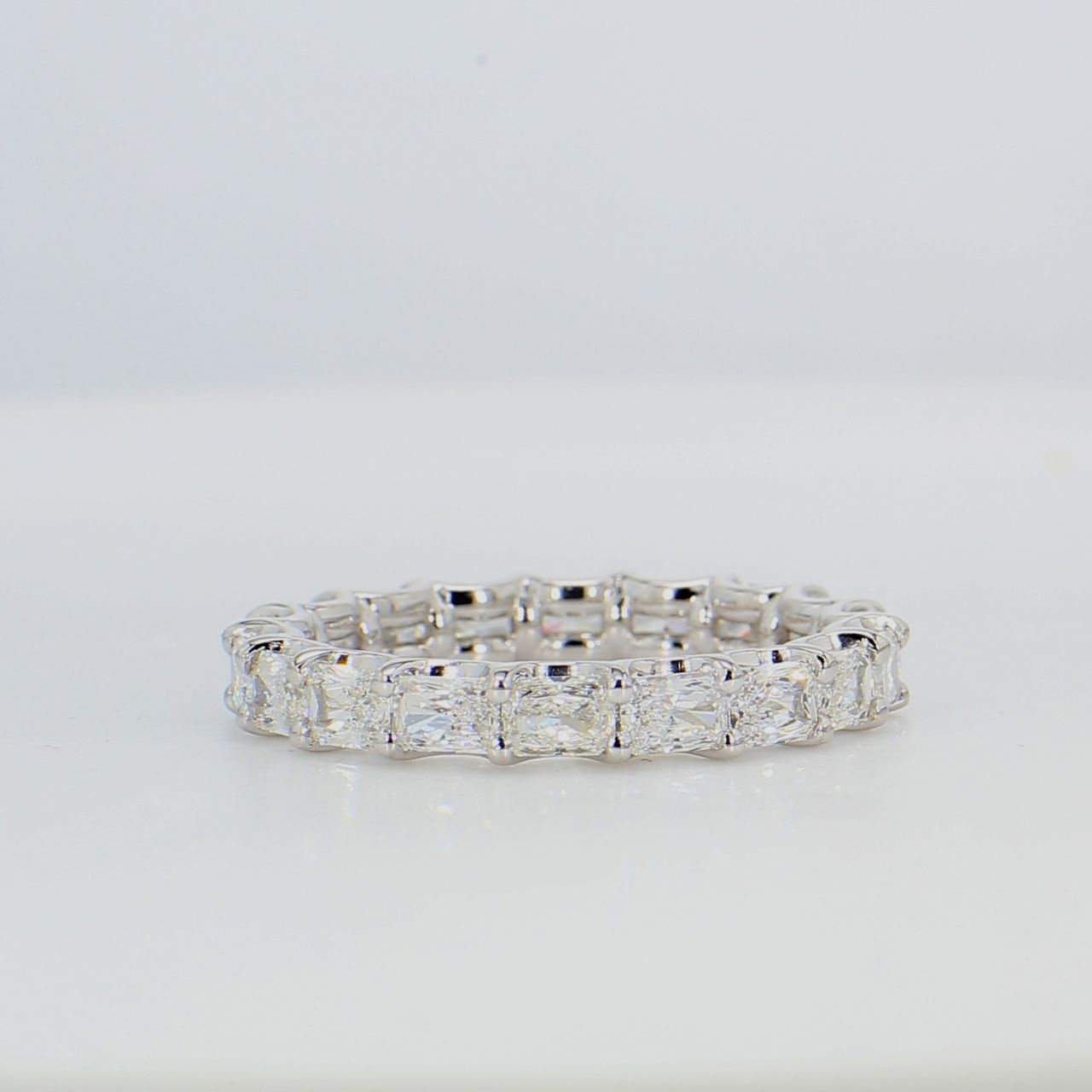 Eternity band east to west style in platinum with shared U-prong set radiant cut diamonds.  D2.80ct.t.w.  Size 7