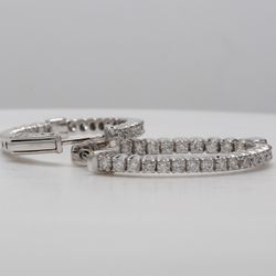 1' Oval shaped inside out hoop earrings with shared prong set round diamonds.  D0.96ct.t.w.