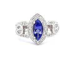 Ring in platinum with pave set rounds, bezel set oval diamonds and 4-prong set Tanzanite centerstone.  D1.10ct.t.w.  (Tanzanite - 1.05ct.)