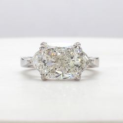 3-stone ring in platinum with prong set J/SI1 GIA certified cushion cut center and trilliant diamond sides.  D5.72ct.t.w.  (Center - 5.01ct.)  Size 6.25