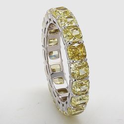 Eternity band in 18K WG with shared prong set fancy yellow (18) cushion cut diamonds.  D6.04ct.t.w.  Size 5.75