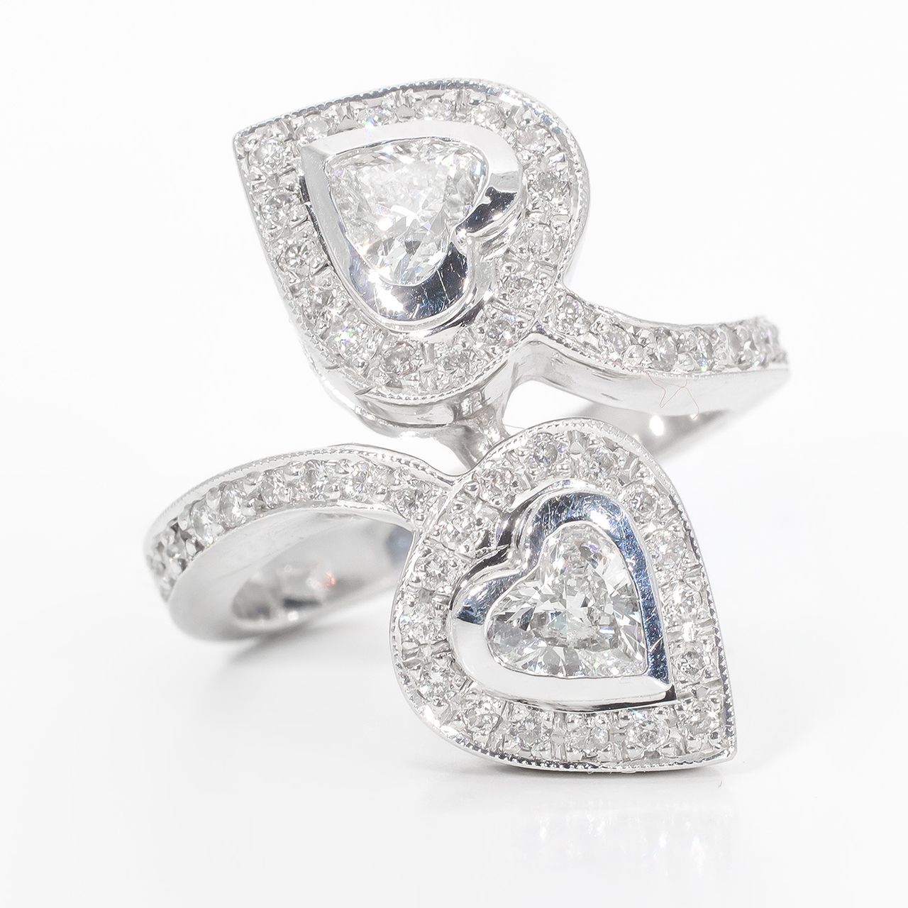 Halo fashion ring with pave set rounds around bezel set heart shape diamond center stones.  D1.22ct.t.w.