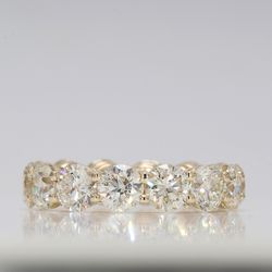 Eternity band in yellow gold with shared prong basket set round diamonds.  D7.34ct.t.w.  Size 7