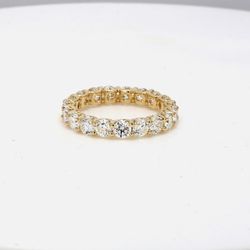 Eternity band in yellow gold with shared u-prong set round diamonds.  D2.96ct.t.w.