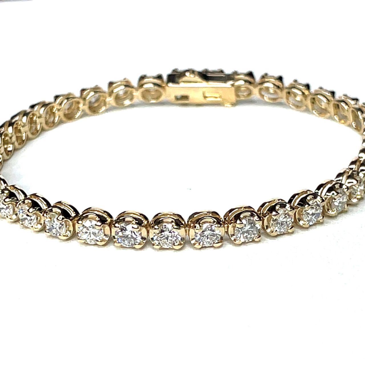 7' Tennis bracelet in yellow gold with illusion style 4-prong set (37) round diamonds.  D5.57ct.t.w.
