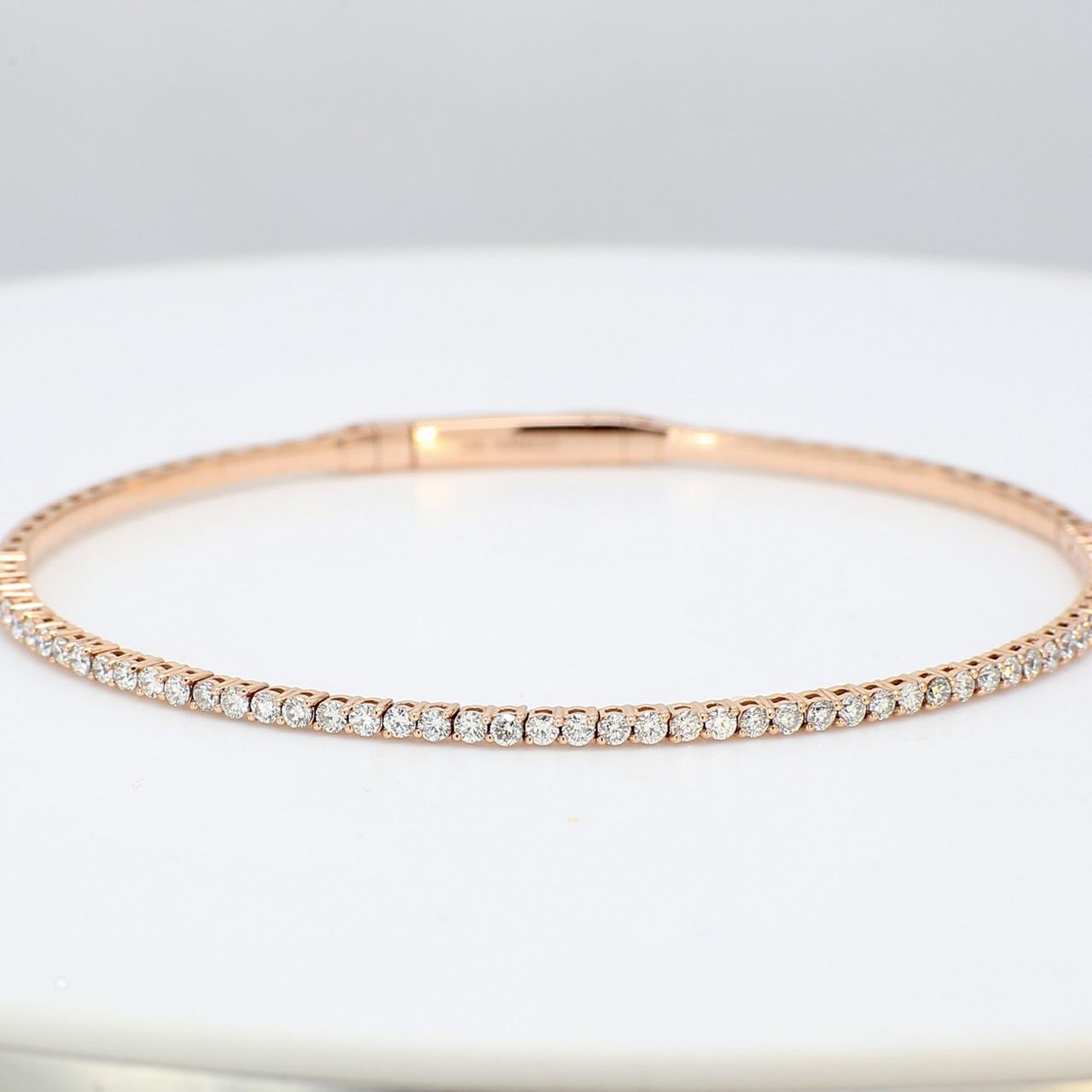 6.5' Lightweight flexible oval shaped bangle in 18K RG with prong set round diamonds.  D1.02ct.t.w.