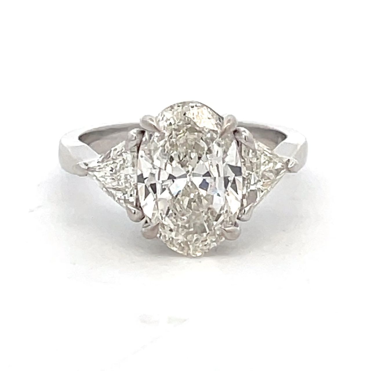 3-stone semi-mount in platinum with prong set trilliant diamond side stones.  D0.69ct.t.w.  Size 6.5