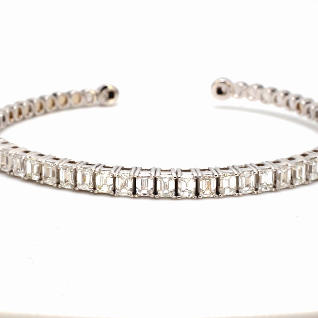 Open cuff bangle in 18K WG with basket prong set (26) emerald cut diamonds.  D3.89ct.t.w.