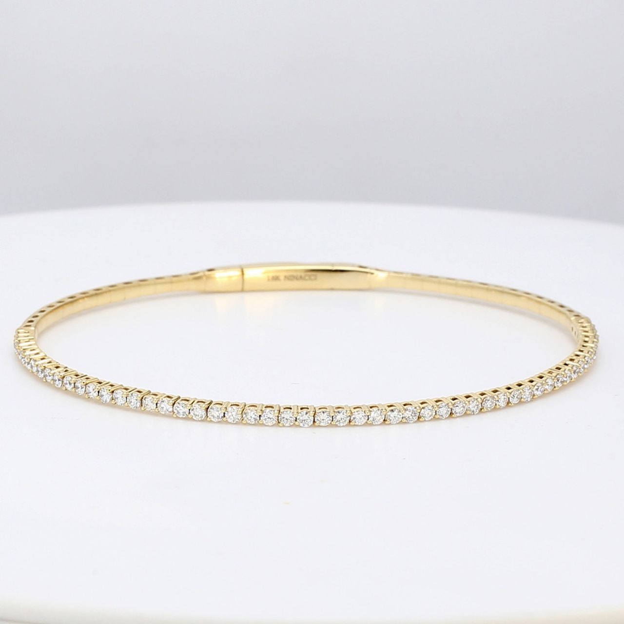 Lightweight flexible oval shaped bangle in 18K YG with prong set round diamonds.  D1.02ct.t.w.