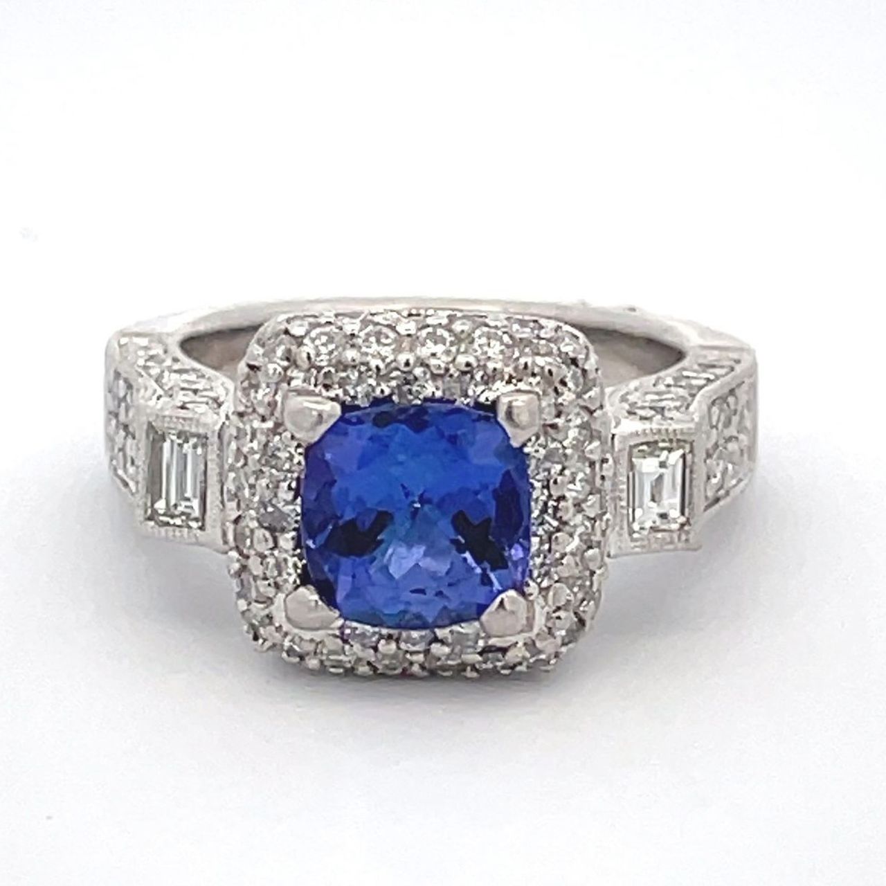 3-stone halo ring in platinum with bezel set baguettes, pave set round diamonds and 4-prong set cushion shape tanzanite center.  D1.55ct.t.w.  (Tanzanite - 1.50ct.)