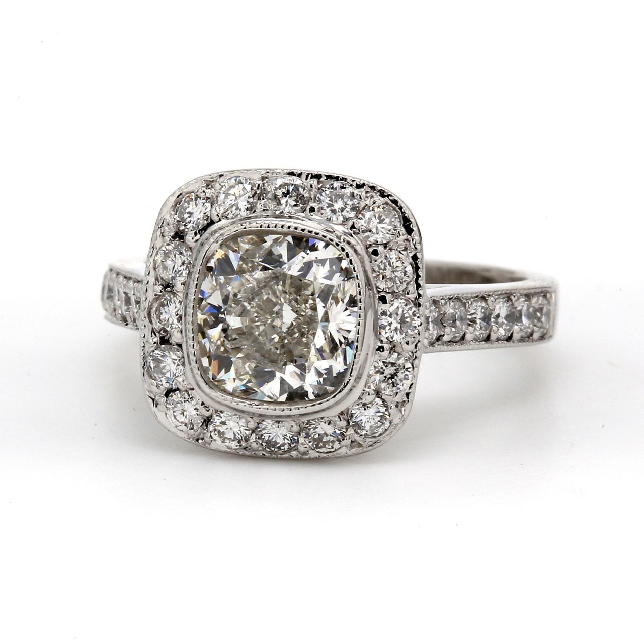 Halo ring in platinum with bezel set USA certified G/SI1 cushion cut center and pave set round diamonds.  D2.92ct.t.w.  (Center 2.02ct.)  Size 6.5