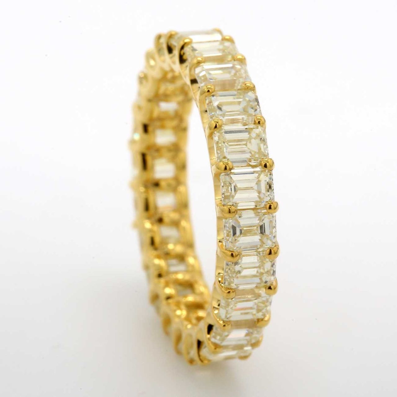 Eternity band in 18K YG with shared U-prong set FY/VS (23) emerald cut diamonds.  D4.55ct.t.w.  Size 6