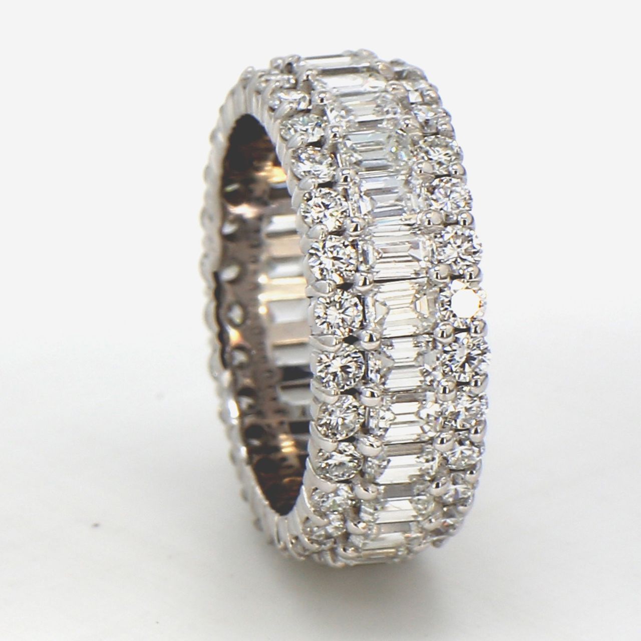 Eternity band in 18K WG with combination prong set emeralds and round diamonds.  D4.30ct.t.w.  Size 4.75