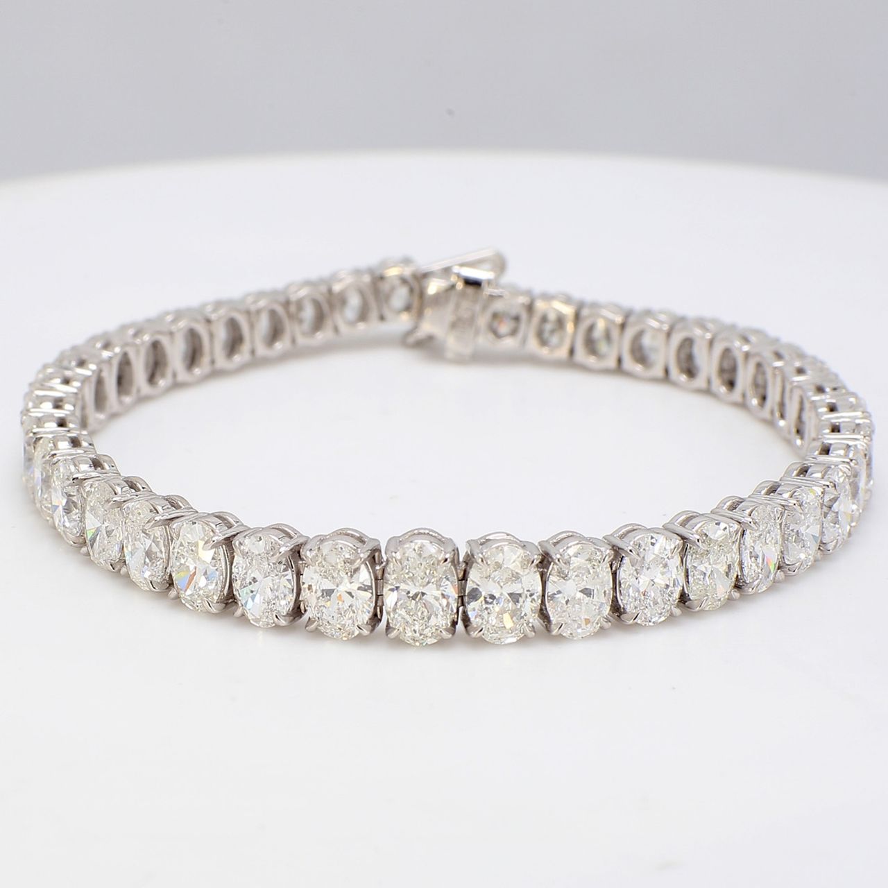 6.5' Graduated tennis bracelet in platinum with basket shared prong set oval diamonds.  D13.41ct.t.w.