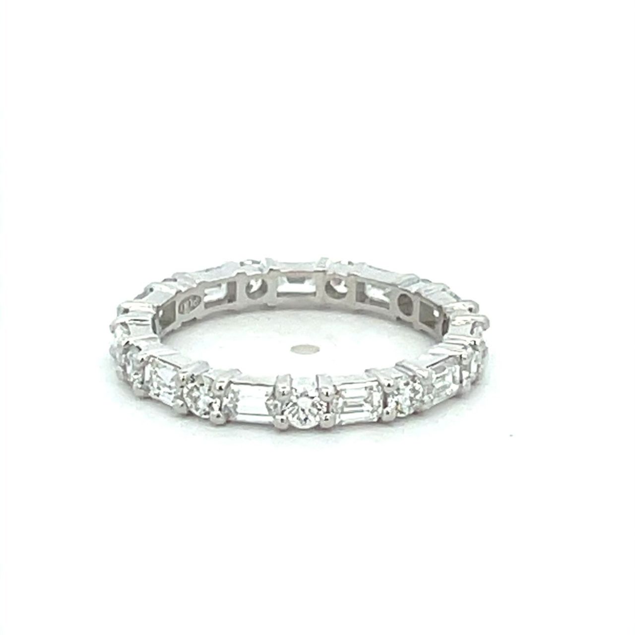 Eternity band east west style in platinum with prong set alternating (11) emerald cuts and (11) round diamonds.  D1.42ct.t.w.  Size 5