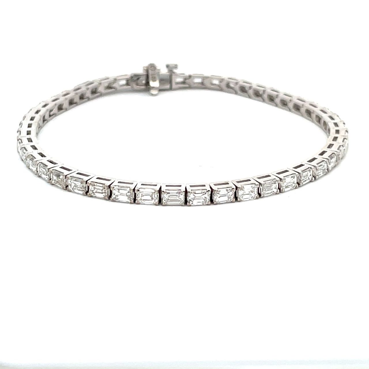 7' Tennis bracelet east west style in 18K WG with open basket prong set (47) emerald cut diamonds.  D5.98ct.t.w.