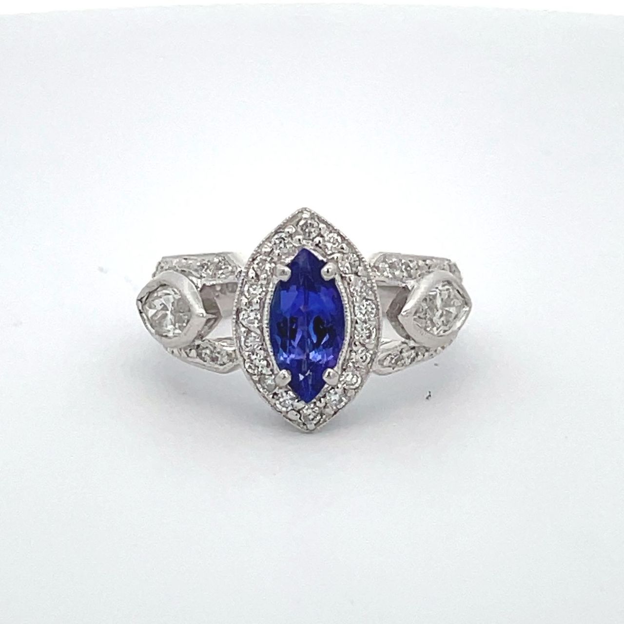Antique style ring in platinum with round & marquise diamonds and a 4-prong set marquise shaped tanzanite center.  D1.25ct.t.w. (Tanzanite - 1.10ct.)