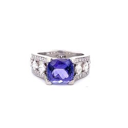 Split-shank ring in platinum w/ channel set princess cuts, pave set round diamonds & 4-prong set cushion cut tanzanite center.  D1.12ct.t.w.  (Tanzanite - 3.43ct.)