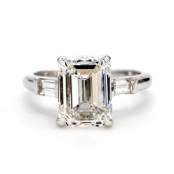 3-stone ring in platinum with channel set baguette sides and F/SI2 GIA certified emerald center.  D3.90ct.t.w.  (Center - 3.51ct.)