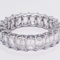 Eternity band in platinum with  shared U-prong set emerald cut diamonds.  D6.79ct.t.w.