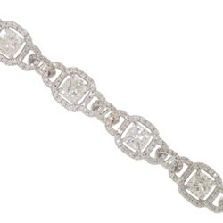 Halo bracelet in 18K WG with pave set rounds around prong set cushion cut diamond center stones.  D8.68ct.t.w.