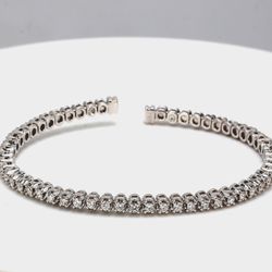 Open flex bangle in yellow gold with 4-prong basket set round diamonds.  D1.56ct.t.w.