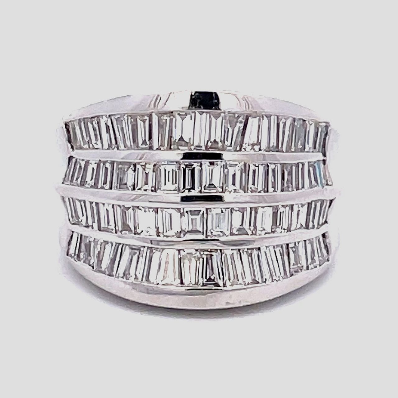 Wide graduated band in 18K WG with 4-row channel set baguette diamonds D3.25ct.tw.  Size 6.75