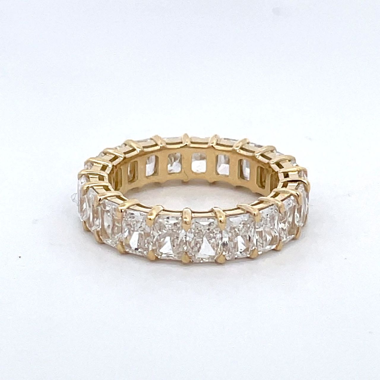 Eternity band in 18K YG with open basket prong set (21) radiant cut diamonds.  D5.46ct.t.w.  Size 6