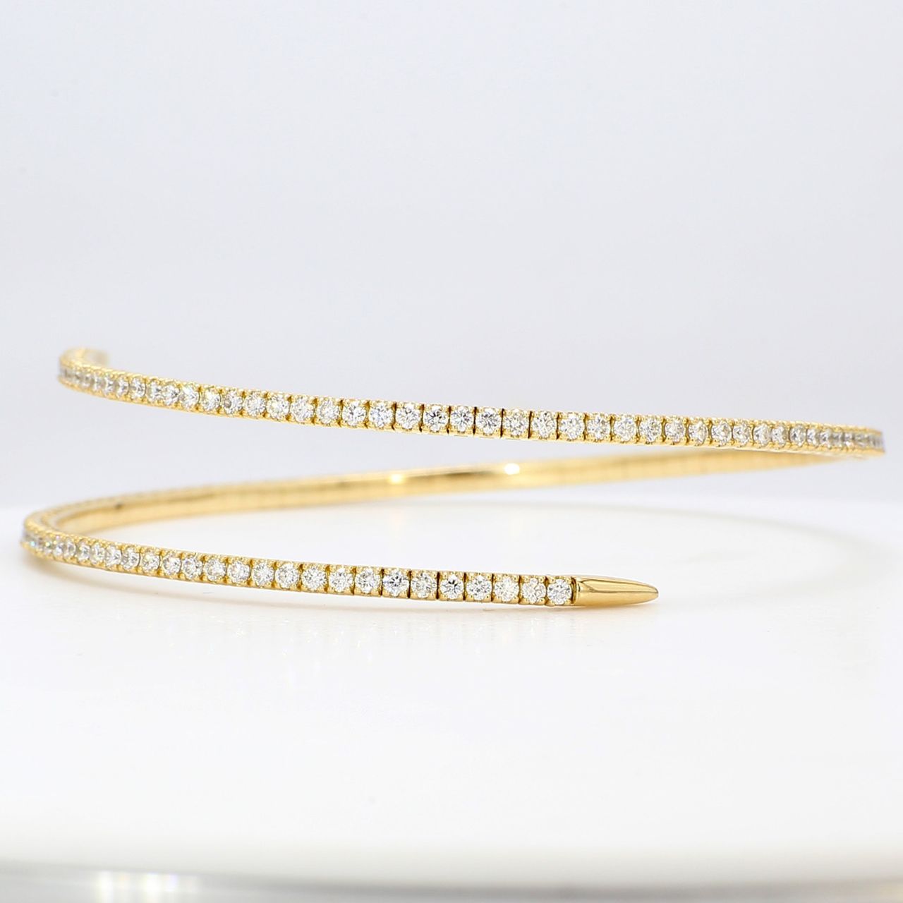 Flexible bangle in 18K YG with 4-prong set round diamonds.  D2.28ct.t.w.