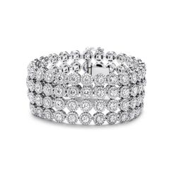 Halo 4-row bracelet in 18K WG with French pave set rounds around prong set round diamond center stones.  D26.92ct.t.w.