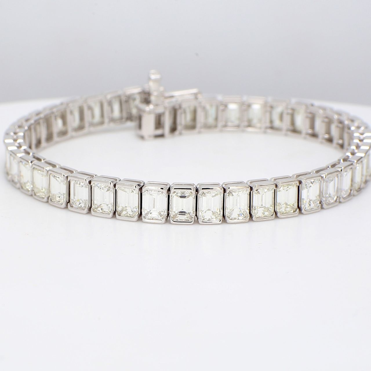 7' Tennis bracelet in platinum with half bezel set I/VVS-VS emerald cut diamonds.  D15.53ct.t.w.