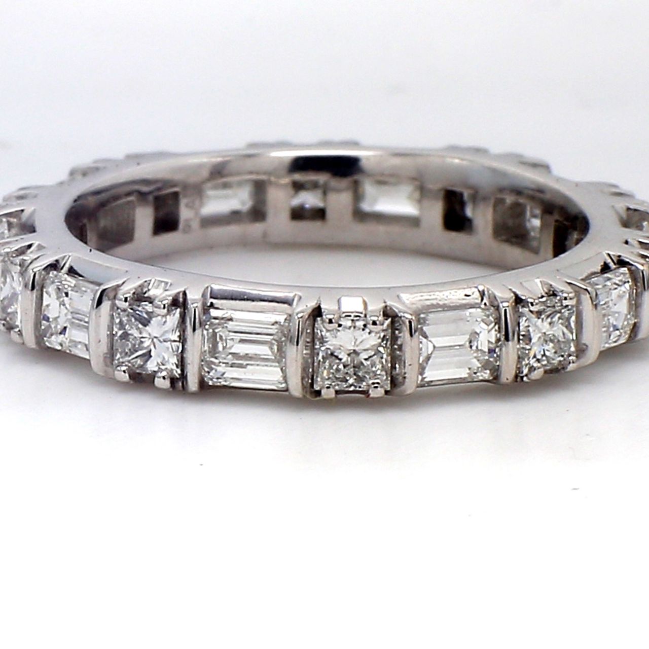 Eternity band bypass style in platinum with prong set (10) emerald cut and (10) princess cut diamonds.  D2.22ct.t.w.  Size 6.25