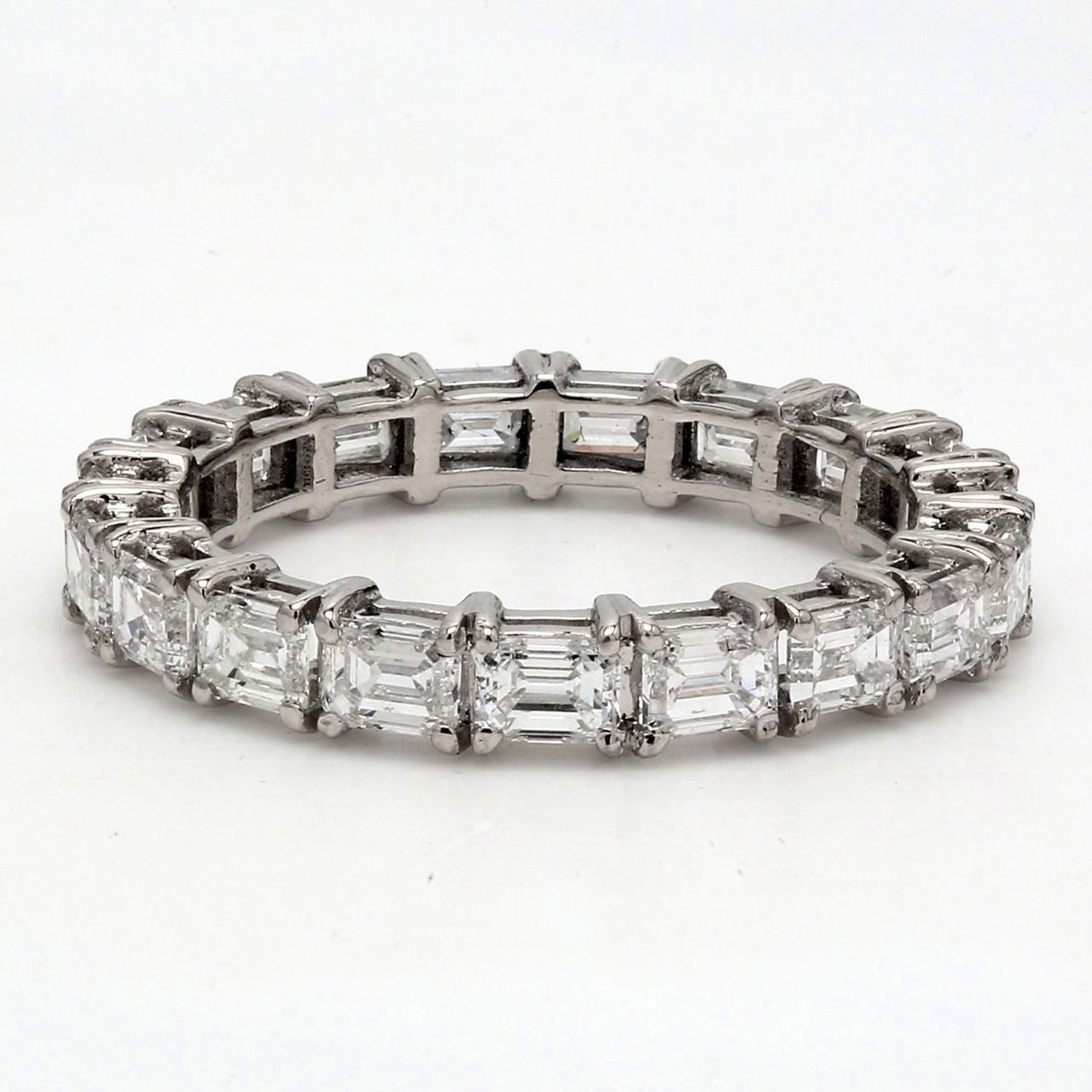 East to west style eternity band in platinum with 4-prong set (19) emerald cut diamonds.  D2.68ct.t.w.  Size 6