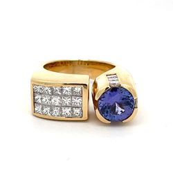 Ring with square shank in 18K YG with channel & 3-row invisible set princess cut diamonds and bezel set tanzanite center.  D3.15ct.t.w.  (Tanzanite - 1.61ct.)