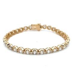 7' Tennis bracelet in yellow gold with illusion prong set round diamonds.  D7.79ct.t.w.