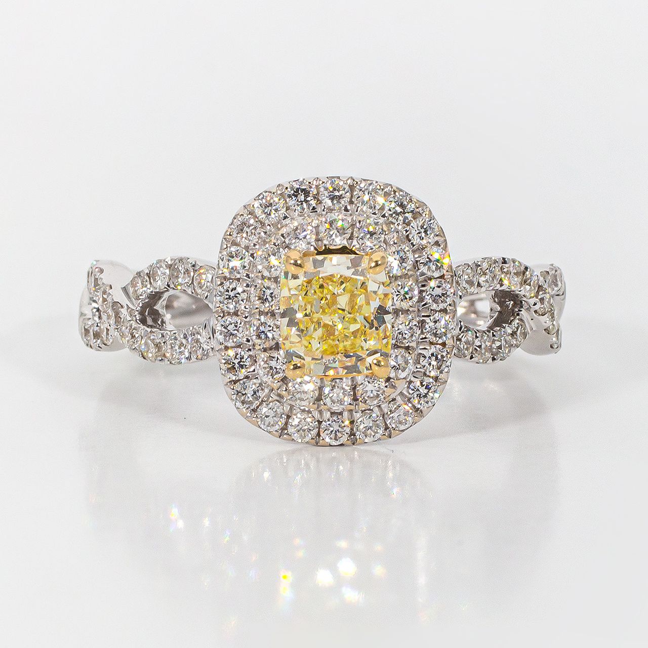 Double halo criss cross shank ring in 18K WG with rounds around a FY cushion cut diamond center stone.  D1.15ct.t.w.  (Center 0.57ct.)  Size 6.75