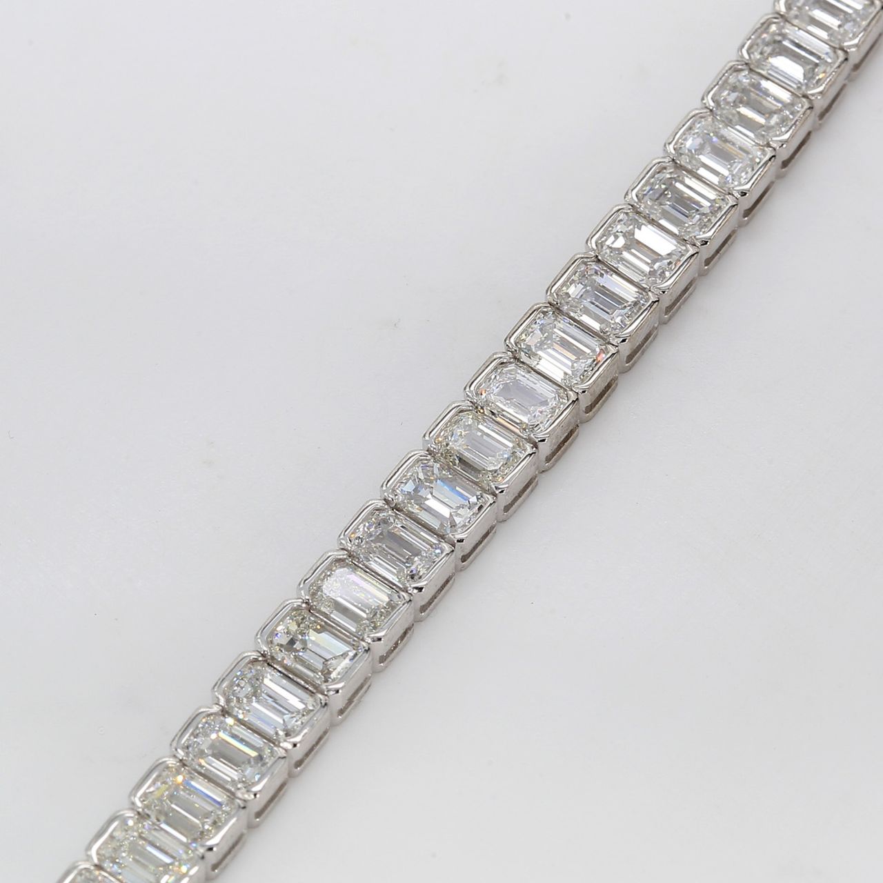 7' Tennis bracelet in platinum with half bezel set emerald cut diamonds.  D13.58ct.t.w.