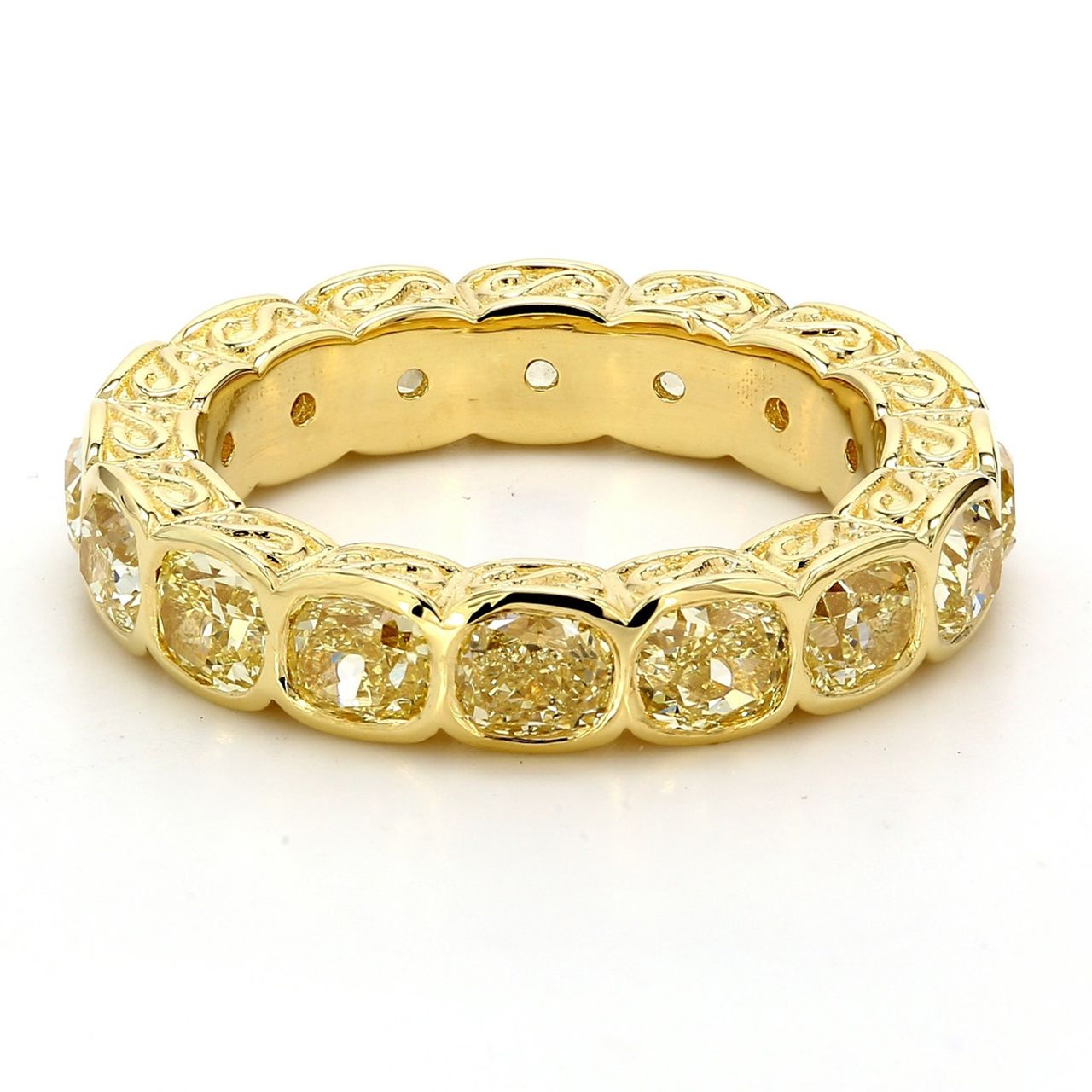 Eternity band in 18K YG with fleur-de-lis design on the sides, & bezel set (16) fancy yellow cushion diamonds.  D4.60ct.t.w.