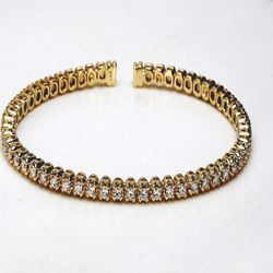 Open flex bangle in yellow gold with 4-prong basket set round diamonds.  D1.56ct.t.w.