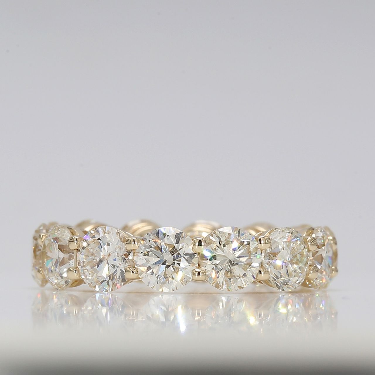 Eternity band in yellow gold with shared prong basket set round diamonds.  D7.34ct.t.w.  Size 7