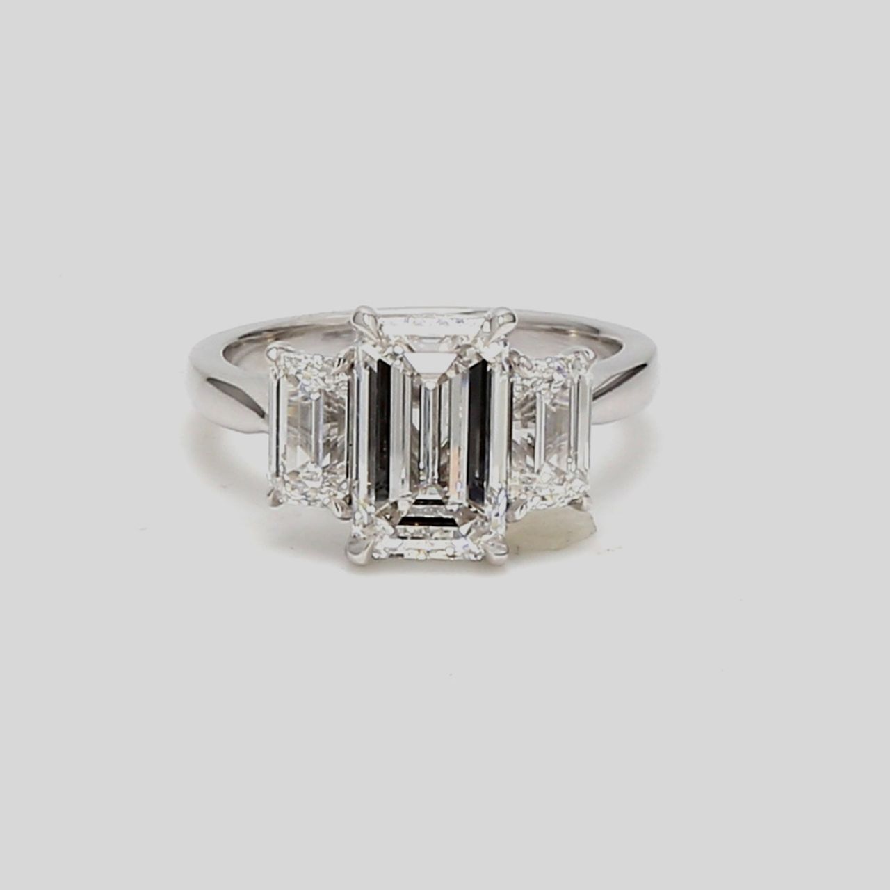 3-stone semi-mount in platinum with GIA certified E/VS2 emerald cut diamond sides.  D1.40ct.t.w.
