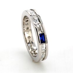 Eternity band in platinum with channel set baguette diamonds &  a baguette shaped sapphire.  D1.38ct.t.w.  Sapphire 0.12ct.