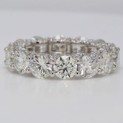 Eternity band in platinum with shared prong set G-H/VS-SI (14) rounds & U-prong set round diamonds on the sides.  D8.36ct.t.w.  Size 6.25
