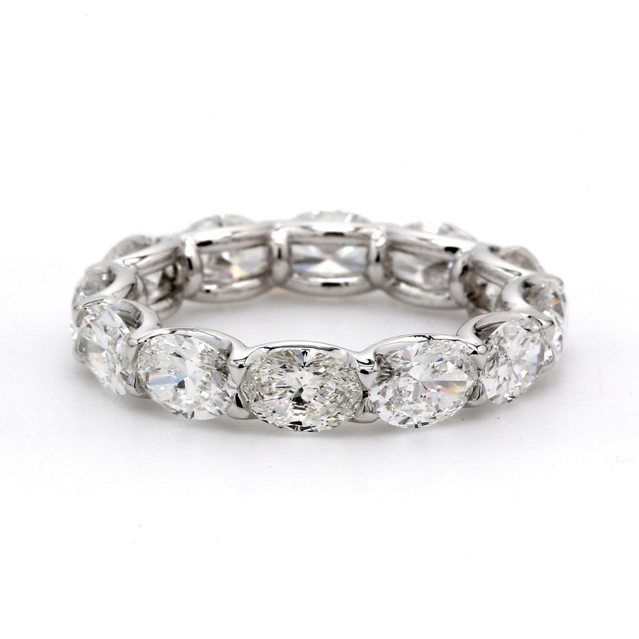 East to west style eternity band in platinum with shared U-prong set (12) oval diamonds.  D3.98ct.t.w.