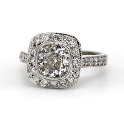 Halo ring in platinum with bezel set USA certified G/SI1 cushion cut center and pave set round diamonds.  D2.92ct.t.w.  (Center 2.02ct.)  Size 6.5