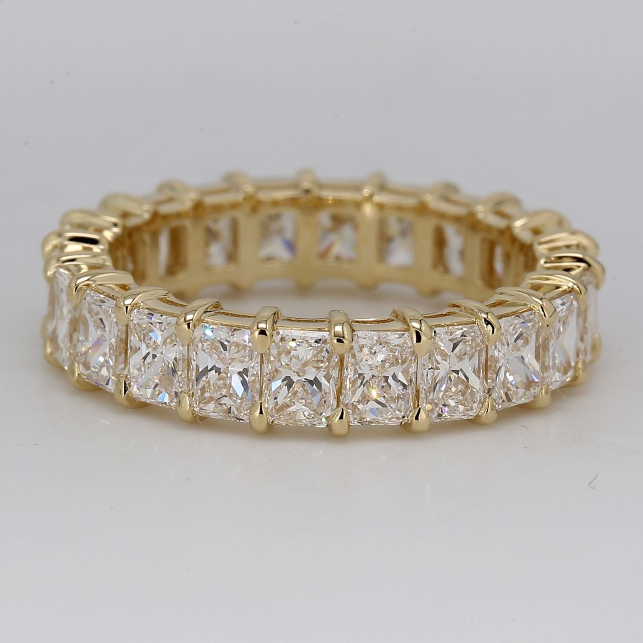 Eternity band in 14K YG with shared claw prong basket set radiant cut diamonds.  D3.40ct.t.w.  Size 5