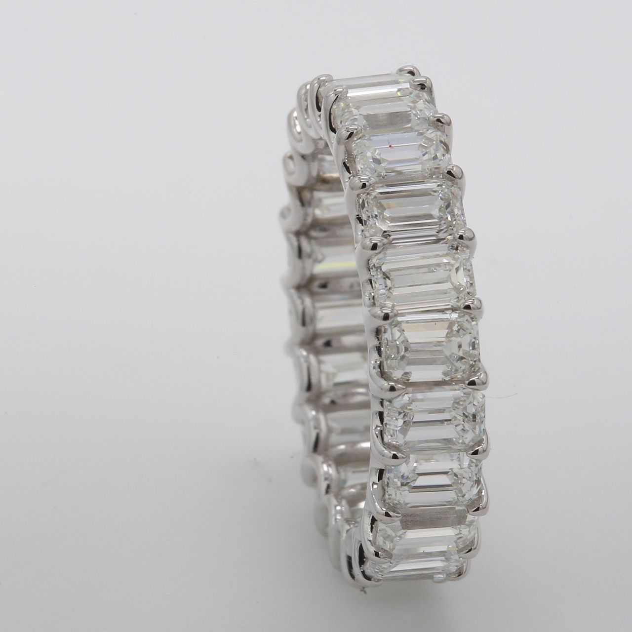 Eternity band in platinum with shared claw U-prong set (20) emerald cut diamonds.  D8.24ct.t.w.  Size 7.25