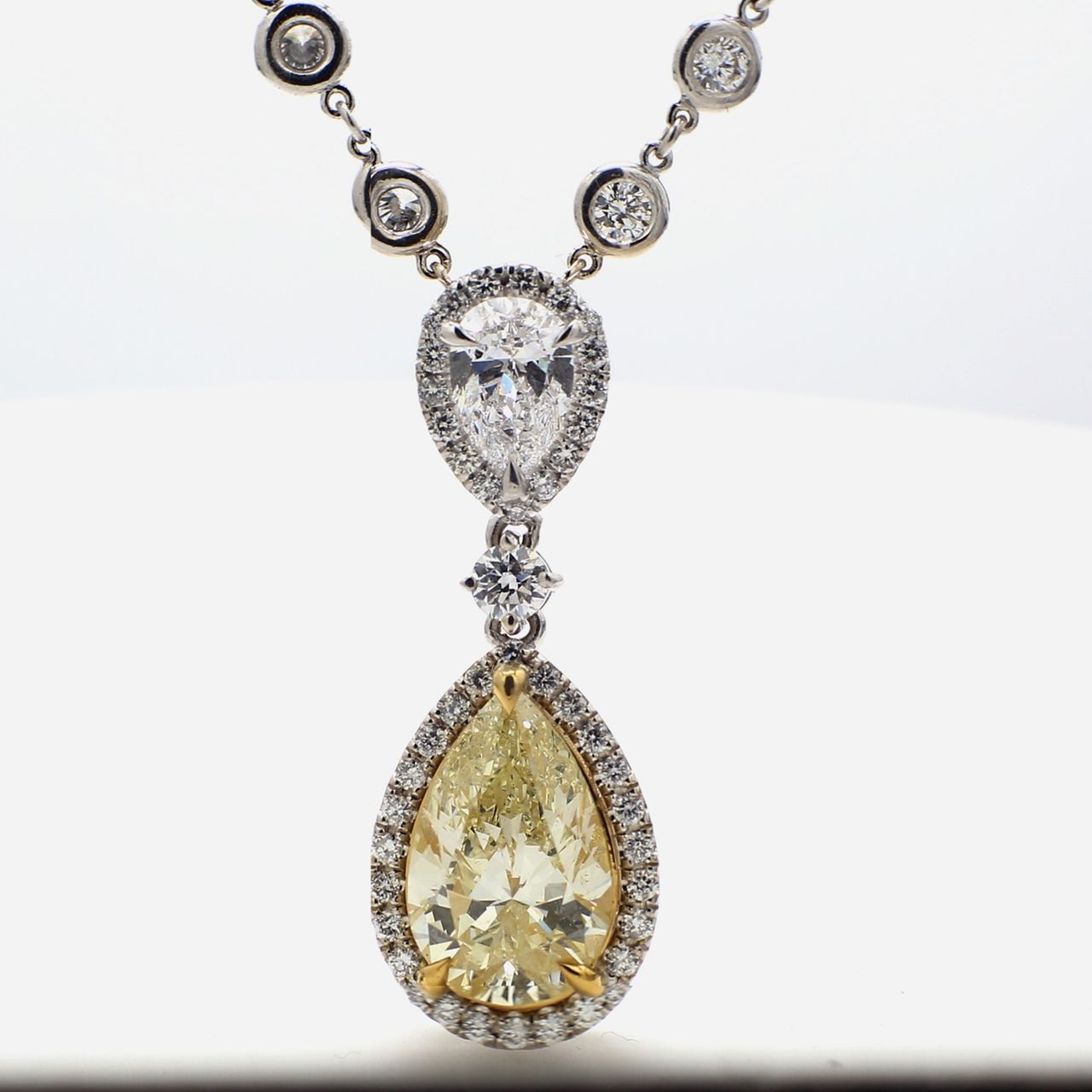 17.5' Halo drop necklace in platinum/18K YG with bezel set rounds, D/SI2 pear, and FLY/SI2 GIA certified pear shape diamond center stone.  D11.12ct.t.w.  (Center - 5.03ct.)