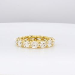 East to west style eternity band in 18K YG with 4-prong set (13) oval cut diamonds.  D3.43ct.t.w.  Size 5