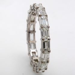 East to west style eternity band in 18K WG with shared prong basket set (17) emerald cut diamonds.  D3.14ct.t.w.  Size 6.5